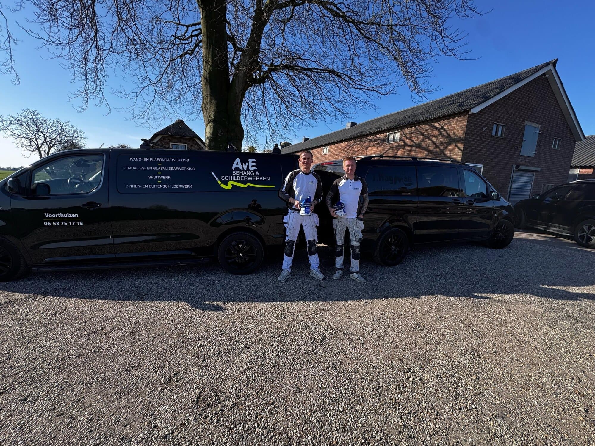Het team van AvE Behang en Schilderwerken bij de bedrijfsbussen
